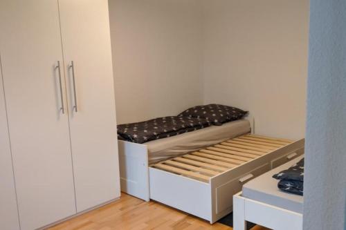 Habitación pequeña con cama y armario en NEU! Moderne Ferienwohnung Ulm, en Ulm
