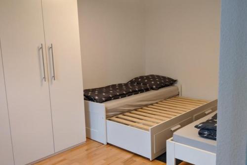 een kleine kamer met een bed en een kast bij NEU! Moderne Ferienwohnung Ulm in Ulm