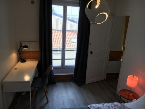 Cette chambre dispose d'un bureau et d'une fenêtre avec une décoration élégante. dans l'établissement appartement T2 porte de Pantin Métro Hoche, à Le Pré-Saint-Gervais