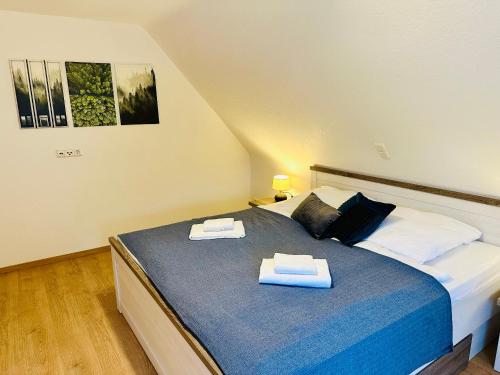 a bedroom with a bed with two towels on it at Haus Brockenblick in Bad Harzburg