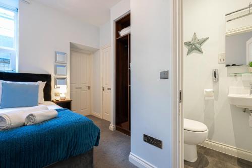 a bedroom with a bed and a toilet and a sink at Ocean Stays - Boutique Hotel on Plymouth Hoe in Plymouth