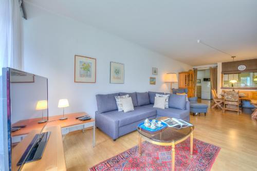 a living room with a blue couch and a table at Casa Sibylle with Sauna and Pool - Happy Rentals in Riva San Vitale