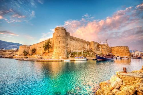 a large castle sitting on top of a body of water at ANADOL Hotel & Pool next to Kyrenia Harbour in Kyrenia