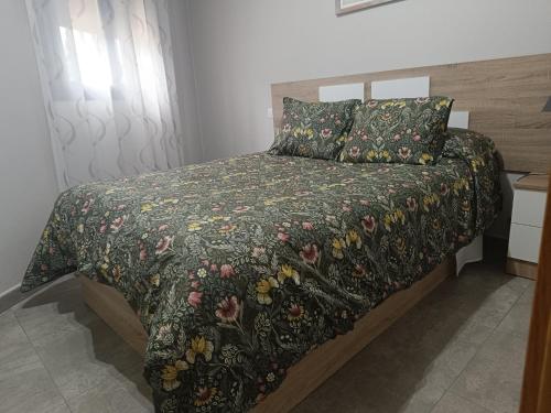 a bedroom with a bed with a floral bedspread at El bosque - CON PARKING GRATIS in Toledo