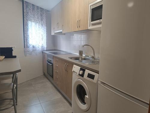 a kitchen with a washing machine and a sink at El bosque - CON PARKING GRATIS in Toledo