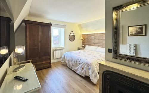 1 dormitorio con cama y espejo grande en Posada Villa Rosa, en Reinosa