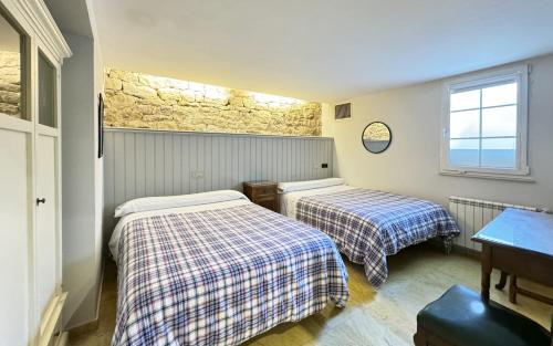 a bedroom with two beds and a window at Posada Villa Rosa in Reinosa
