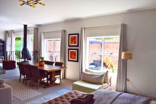 ein Wohnzimmer mit einem Tisch und einem Esszimmer in der Unterkunft Riverclub Guest Suites in Riverclub, Sandton in Johannesburg