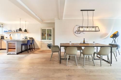cocina y comedor con mesa y sillas en Ferienhaus Silbermöwe 7b en List