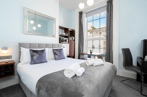 una camera da letto con un grande letto con asciugamani di Ocean Stays Hotel, Plymouth a Plymouth