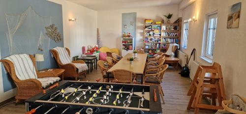 um quarto com uma mesa e cadeiras e um quarto com um tabuleiro de xadrez em Ferienwohnung 'Falshöft' - Refugium Pottloch Ostsee em Kronsgaard