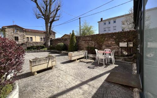 a patio with two chairs and a table and a wall at Posada Villa Rosa in Reinosa