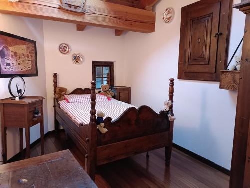 um quarto com uma cama com ursos de peluche em La dzenta méizón em Villeneuve