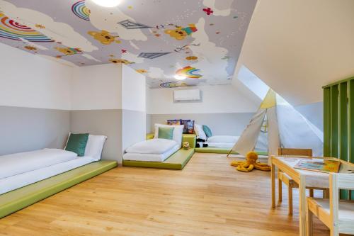 Cette chambre pour enfants est dotée d'un plafond avec un avion de jouets. dans l'établissement Somerset Schönbrunn Vienna, à Vienne