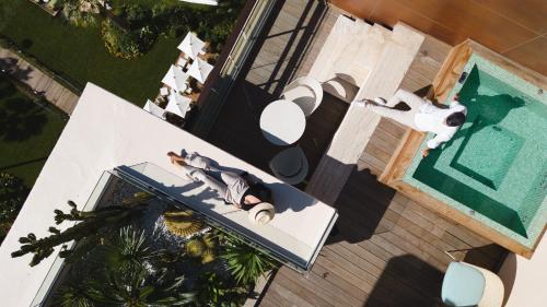 an overhead view of a woman laying on a table next to a pool at Mondrian Cannes in Cannes