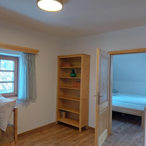 1 dormitorio con cama y estante para libros en Apartmány Marie Albeř, en Nová Bystřice