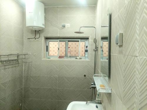 uma casa de banho com um lavatório e um espelho em Belle loge de 5 pièces à proximité de l'aéroport em Cotonou