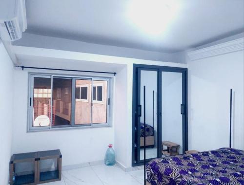 a bedroom with a bed and a window at Belle loge de 5 pièces à proximité de l'aéroport in Cotonou