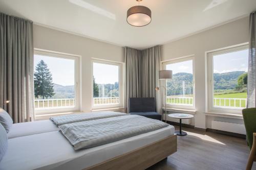 um quarto com uma cama e janelas grandes em St. Bonifatius em Winterberg