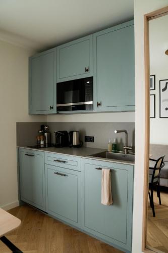 a kitchen with white cabinets and a sink and a microwave at Bob W Lübeck Old Town in Lübeck