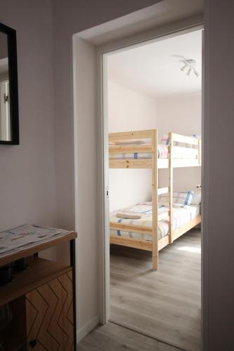 una puerta que conduce a un dormitorio con 2 literas en Cómodo piso en el Pirineo Aragonés, en Sabiñánigo