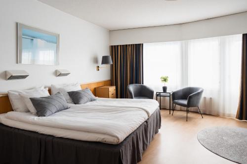 um quarto de hotel com uma cama, uma mesa e cadeiras em Hotel Waltikka em Valkeakoski