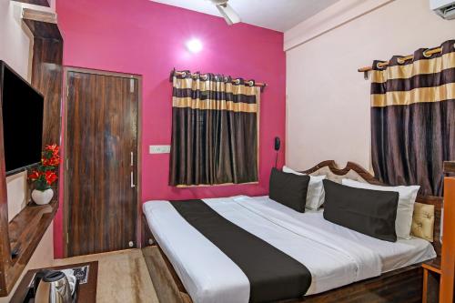 a bedroom with a large bed with a pink wall at HOTEL DASH LIVING in Dum Dum