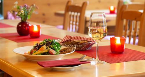 a table with a plate of food and a glass of wine at Victor's Residenz-Hotel Erfurt in Erfurt