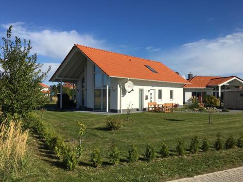 a white house with an orange roof at Villa Große Freiheit in Trent