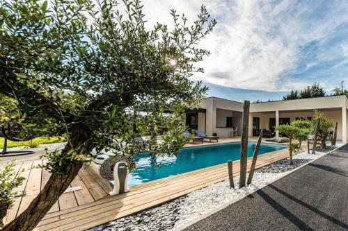 une piscine devant une maison dans l'établissement VILLA ***** PISCINE CHAUFFÉE, JACCUZI, PÉTANQUE, à Moirax