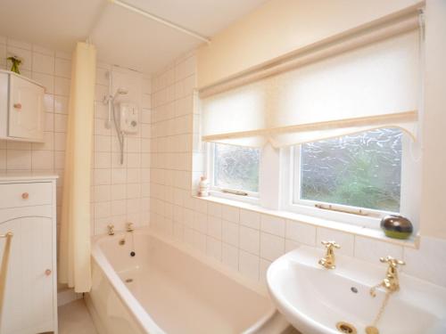 ein Bad mit einem Waschbecken, einer Badewanne und einem Fenster in der Unterkunft 2 Bed in Youlgreave 46087 in Youlgreave