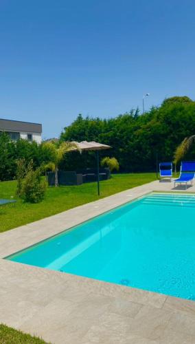 a swimming pool with two chairs and an umbrella at San Michele Apartments&Rooms in Catanzaro
