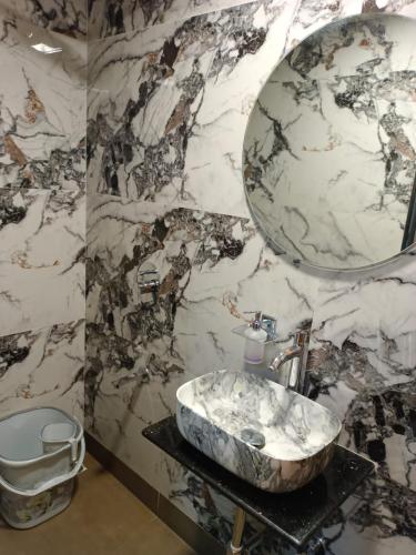 a marble bathroom with a sink and a mirror at Hotel airport annex in Mumbai
