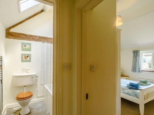 a bathroom with a toilet and a bed in a room at 1 bed in Shaftesbury 52108 in East Knoyle