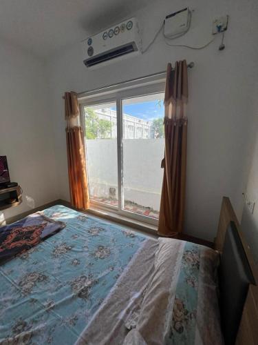 a bedroom with a bed and a large window at Villa 15 - 2 BHK villa in Pondicherry in Marakkānam