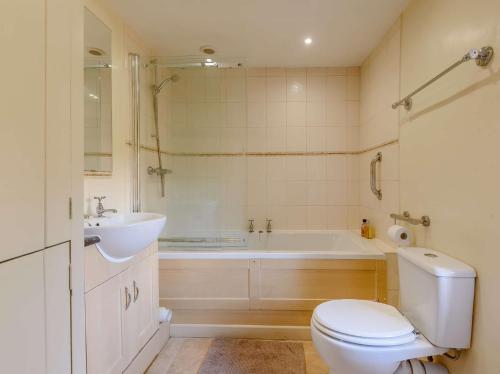 a bathroom with a tub and a toilet and a sink at 2 Bed in Winster PK885 in Winster