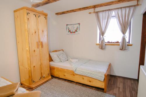 ein kleines Schlafzimmer mit einem Bett und einem Fenster in der Unterkunft Kuća za odmor Ana in Josipdol