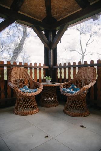 two wicker chairs and a table on a porch at Kuća za odmor Ana in Josipdol