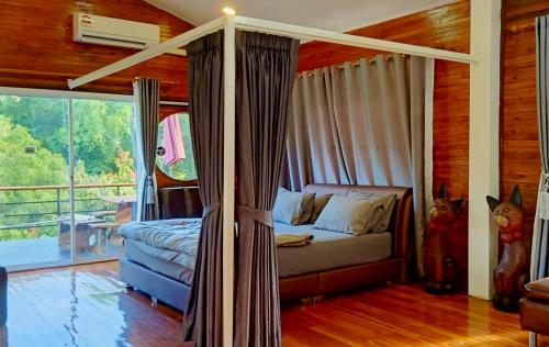 sypialnia z łóżkiem w pokoju z oknem w obiekcie ธารน้ำ รีสอร์ท เขาค้อ w mieście Ban Khao Ya Nua