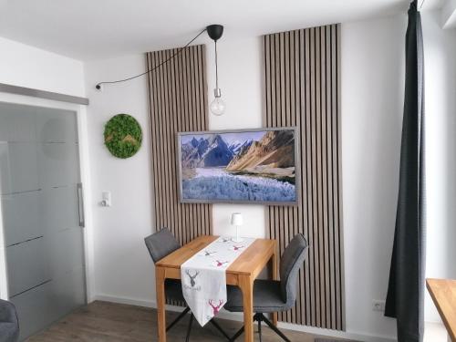 uma sala de jantar com uma mesa e uma imagem na parede em Ferienwohnung Astenrefugio em Winterberg