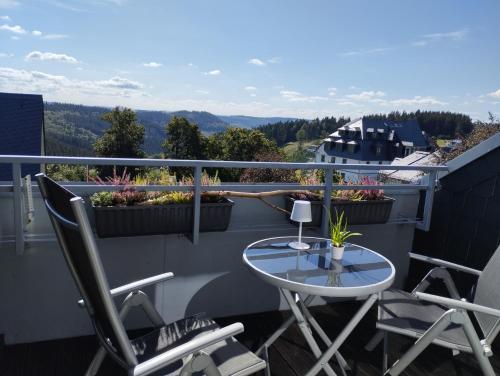 balcón con mesa, sillas y vistas en Ferienwohnung Astenrefugio, en Winterberg