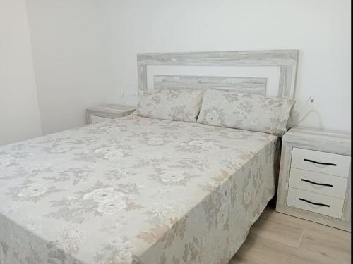 クベリャスにあるEl Mar de Cubelles Primera Lineaの白い壁のベッドルーム1室(大型ベッド1台付)
