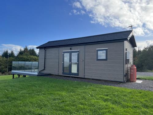 a tiny house with a bench in a yard at Warren Farm Retreat - Pod 1, Pod 2, and The Lodge by SSW in Cardiff