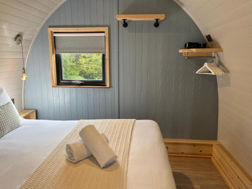 Schlafzimmer mit einem Bett und einem Fenster in der Unterkunft Warren Farm Retreat - Pod 1, Pod 2, and The Lodge by SSW in Cardiff