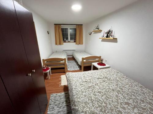 a small room with two beds and a window at Apartman Cogan - 100m from Gondola - Brzece in Kopaonik