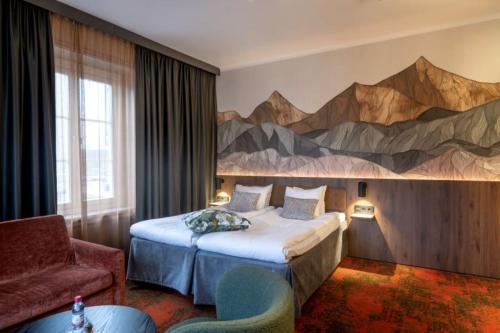 a hotel room with a bed and a painting on the wall at Clarion Collection Hotel Bergmästaren in Falun