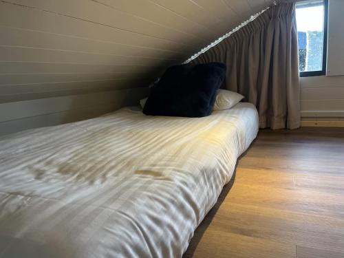 a bed with two pillows on it in a room at Warren Farm Retreat - Pod 1, Pod 2, and The Lodge by SSW in Cardiff
