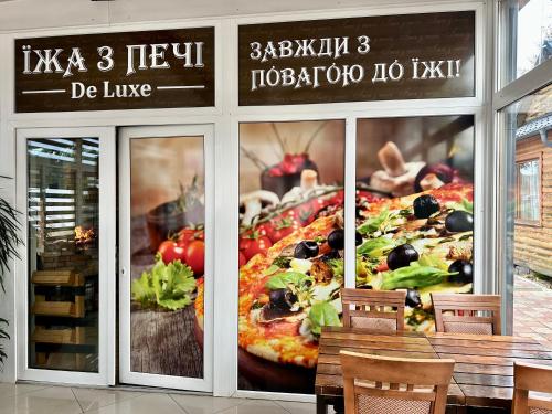 duża pizza w oknie restauracji w obiekcie Котеджне містечко Мацеста 