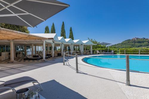 einen Pool in einem Resort mit Sonnenschirm in der Unterkunft Villa Olimpo - Homelike Villas in Pieve a Nievole