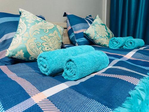 une serviette bleue est posée sur un lit dans l'établissement Апартаменты на Бурова, à Öskemen